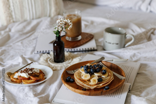 Pancakes with peaches, blueberries and banana in a cozy setting 