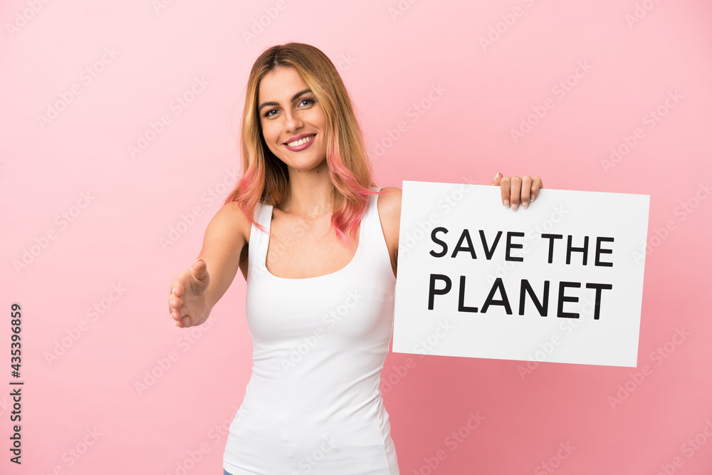 Young woman over isolated pink background holding a placard with text Save the Planet making a deal Young woman over isolated pink background holding a placard with text Save the Planet making a deal