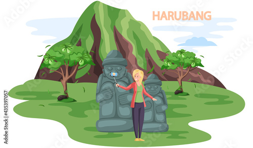 Tourist takes photo near stone sculptures and tropical plants in Stone park. Statue of dol hareubang tourist attraction on Jeju Korean island. Travel to South korea. Welcome to Jeju, vacation in Asia