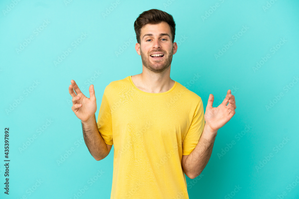 Fototapeta premium Young caucasian handsome man isolated on blue background smiling a lot