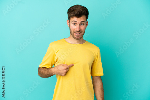 Young caucasian handsome man isolated on blue background with surprise facial expression