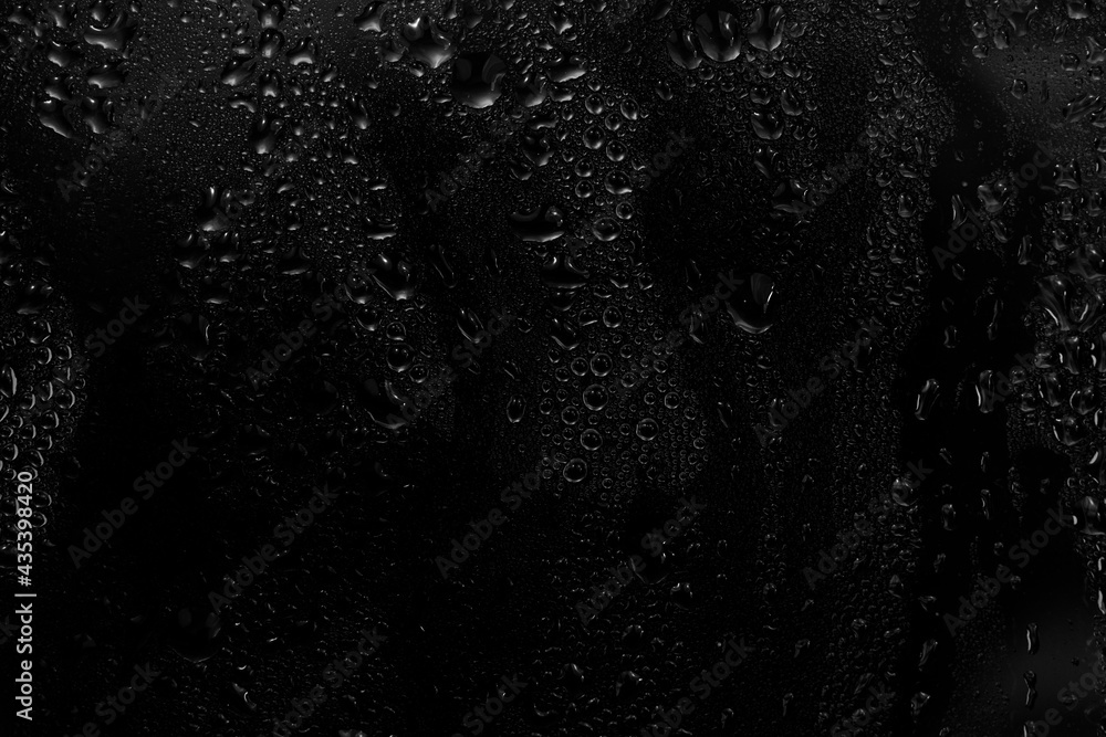 Fototapeta premium water drops on black background. abstract dew water droplets on a window glass for photo overlay effect or giving fresh effect on beverages mockup.