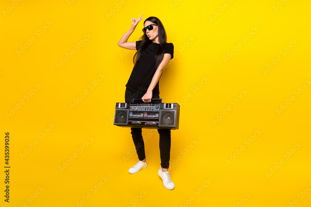 Fototapeta premium Full body photo of excited person hand hold boombox fingers show v-sign isolated on yellow color background
