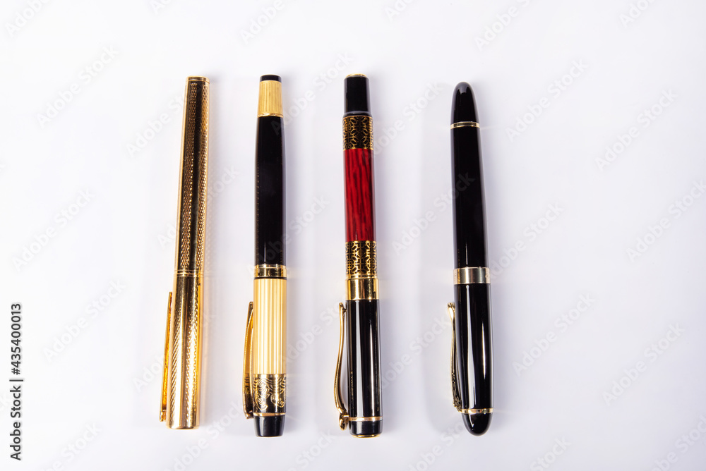 Fountain pen, four beautiful fountain pens in detail on white background, top view. Fountain pen, four beautiful fountain pens in detail on white background, top view.