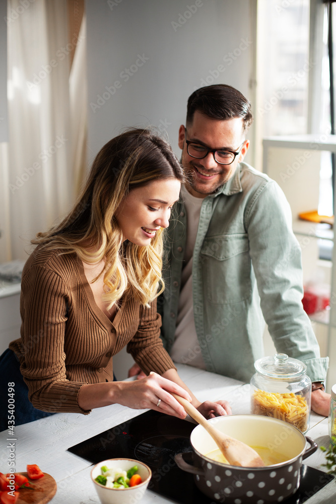 Happy smiling couple cooking together. Husband and wife preparing fresh pasta at home. Happy smiling couple cooking together. Husband and wife preparing fresh pasta at home.