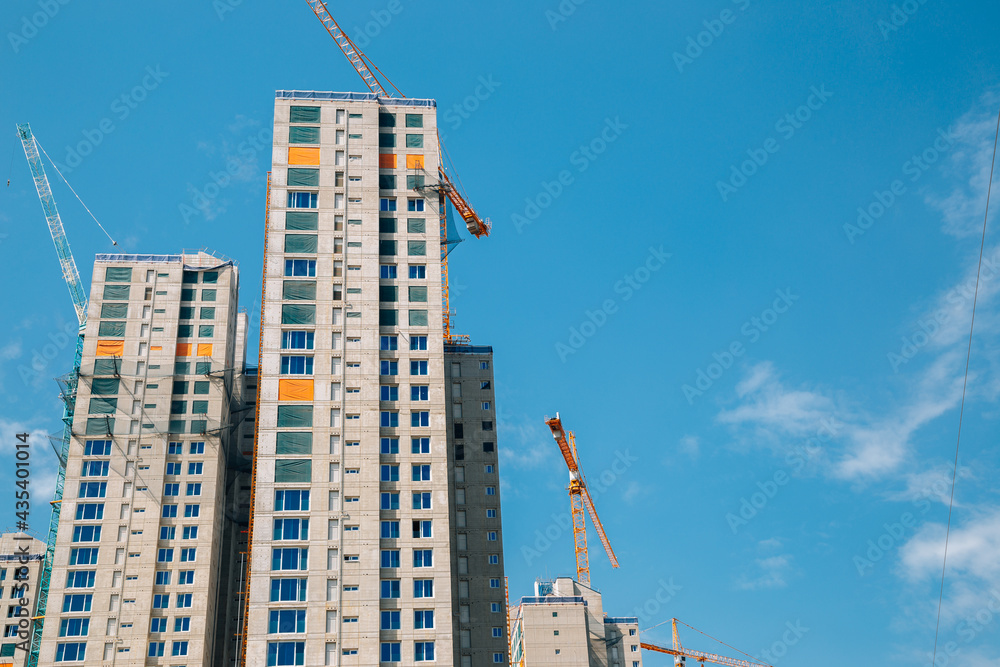 Modern apartment building with crane on construction site Modern apartment building with crane on construction site