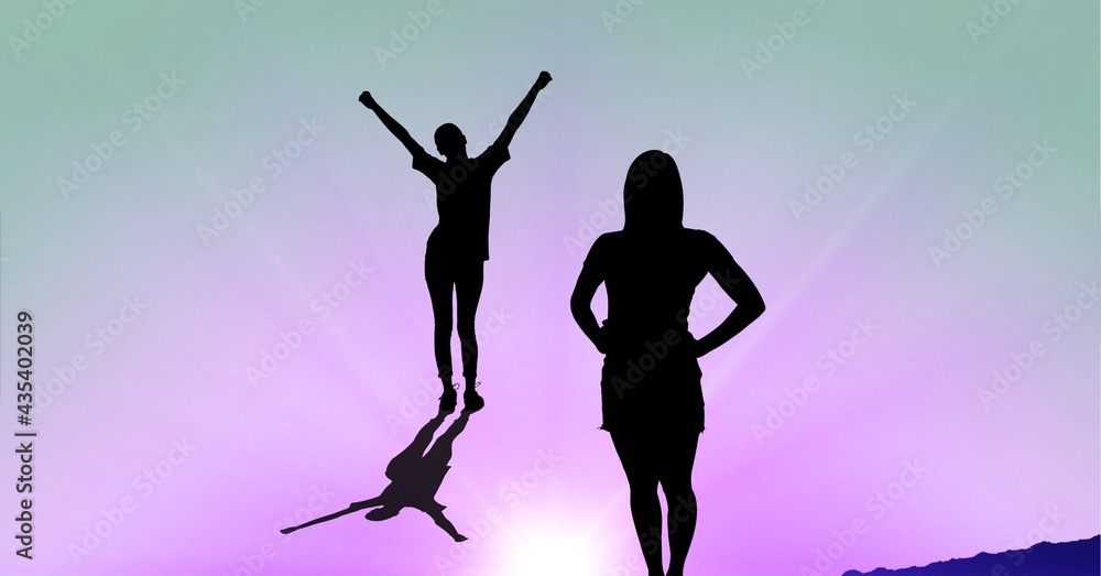Composition of silhouette of women one with arms in air and copy space