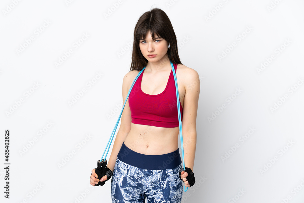Young sport woman isolated on white background with jumping rope