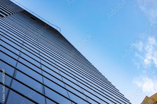 Glass skyscraper against blue sky, view from bottom