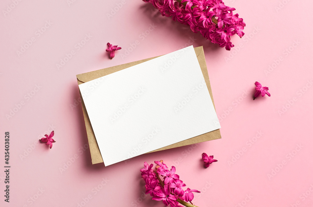 Greeting or invitation card mockup with envelope and hyacinth flowers on pink paper background