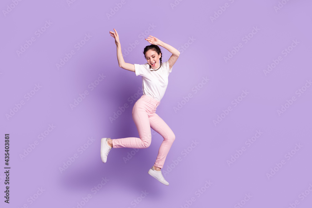 Full size portrait of cheerful girl raise hands toothy smile partying free time isolated on purple color background