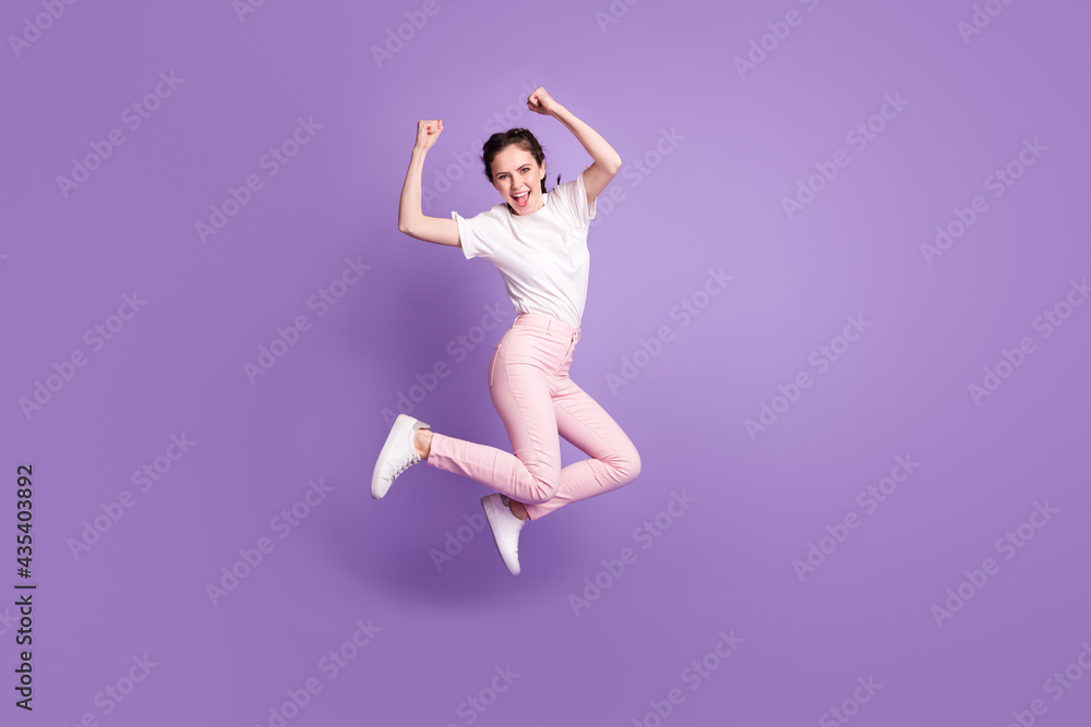 Full body photo of funky cheerful young woman jump up good mood winner isolated on violet color background
