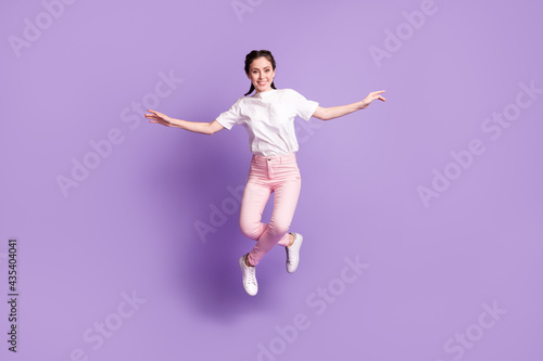 Full body photo of excited satisfied lady arms flying look camera toothy smile isolated on violet color background