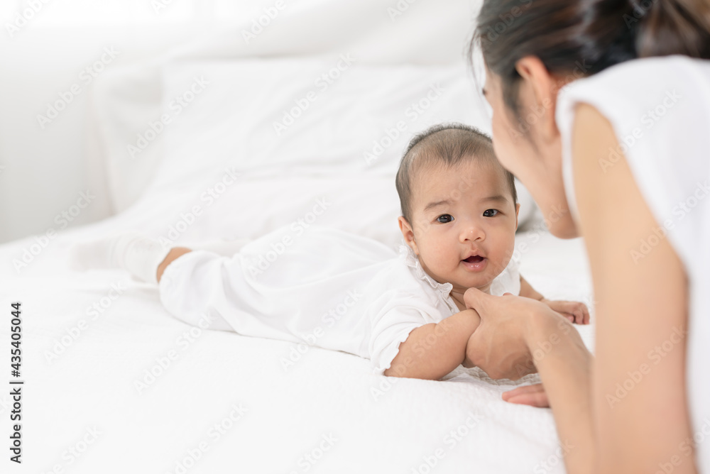 Mother hands holding newborn baby hands eyes contact each other. Beautiful young Asian mother with her newborn baby. Healthcare and medical love lifestyle mother's day concept Mother hands holding newborn baby hands eyes contact each other. Beautiful young Asian mother with her newborn baby. Healthcare and medical love lifestyle mother's day concept