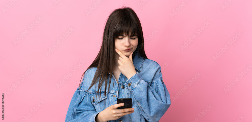 Young Ukrainian woman isolated on pink background thinking and sending a message Young Ukrainian woman isolated on pink background thinking and sending a message