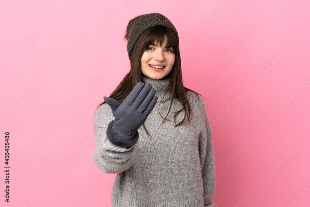 Teenager Ukrainian girl with winter hat isolated on white background inviting to come Teenager Ukrainian girl with winter hat isolated on white background inviting to come