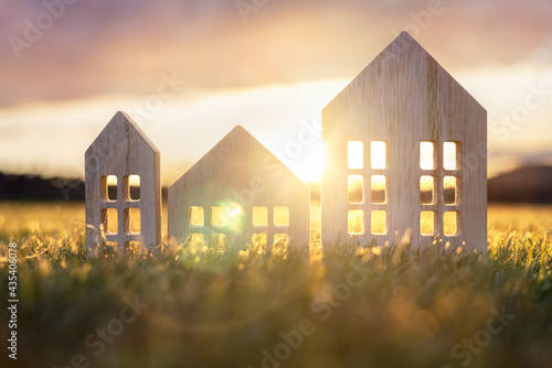 Ecological wood  model house in empty field at sunset