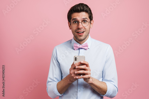 Young white man expressing surprise and using mobile phone © Drobot Dean