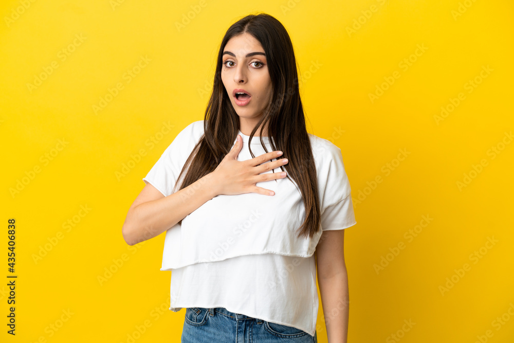 Young caucasian woman isolated on yellow background surprised and shocked while looking right Young caucasian woman isolated on yellow background surprised and shocked while looking right