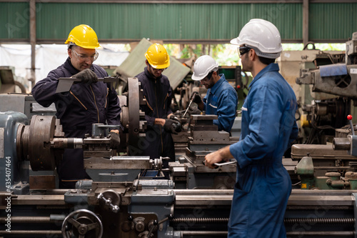 Group of male engineer worker maintenance machine in industry factory. Male technician worker working, repair machine lathe metal in the industry factory photo