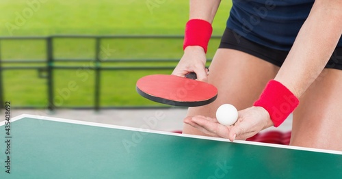 Composition of mid section of female table tennis player holding ball and racket