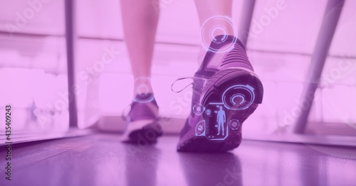 Composition of digital interface over woman's legs exercising on treadmill with pink tint