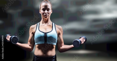 Composition of strong caucasian woman lifting dumbbells with copy space