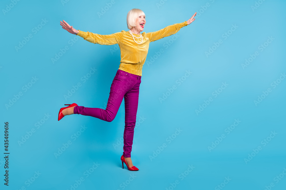 Full size profile photo of nice short hairdo elder lady dance wear blouse pants isolated on blue color background Full size profile photo of nice short hairdo elder lady dance wear blouse pants isolated on blue color background