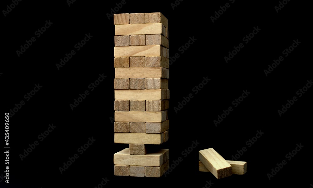 Jenga game. On a black background. There are no two elements at the bottom. Unstable Jenga Jenga game. On a black background. There are no two elements at the bottom. Unstable Jenga