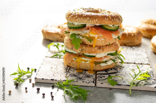 Fresh healthy sandwiches with seeded bagel, mayo, salmon, egg, cucumber and rocket