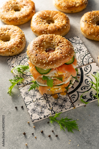 Fresh healthy sandwiches with seeded bagel, mayo, salmon, egg, cucumber and rocket