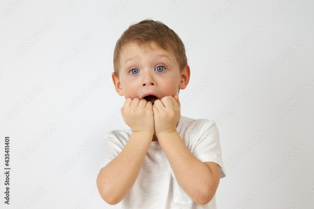 The little boy with the blue eyes put his hands in his mouth, startled. Children's fears The little boy with the blue eyes put his hands in his mouth, startled. Children's fears