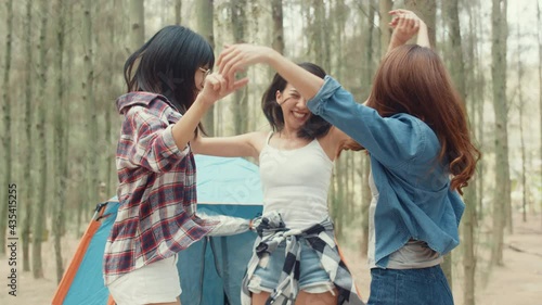 Group of young asia camper friends camping near relax enjoy moment in forest. Happy female traveler traveler success and fun at campsite. Outdoor activity, adventure travel, or holiday vacation.