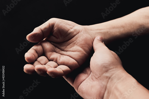 Senior health care provider. Home care for mature people. The caregiver makes elderly feel safe. Concept of family assistance and helping older adults. The aged wrinkled skin hand on black background.