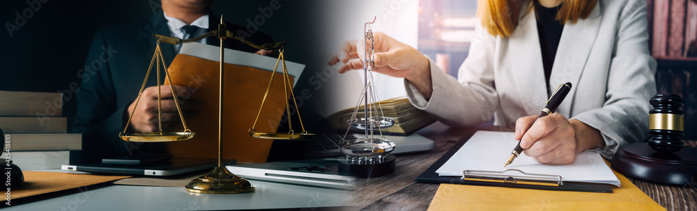 Justice and law concept.Male judge in a courtroom with the gavel, working with, computer and docking keyboard, eyeglasses, on table in morning light Justice and law concept.Male judge in a courtroom with the gavel, working with, computer and docking keyboard, eyeglasses, on table in morning light