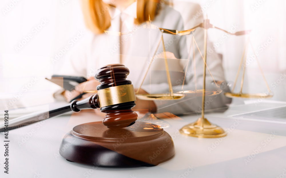 Justice and law concept.Male judge in a courtroom with the gavel, working with, computer and docking keyboard, eyeglasses, on table in morning light