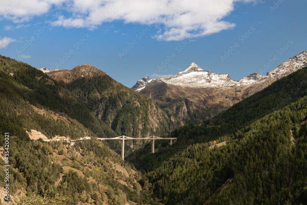 Ausblick entland der Simplonstraße in der Schweiz auf Berge und Brücke und Wäder