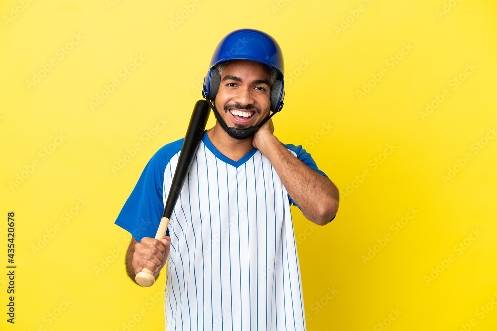 Young Colombian latin man playing baseball isolated on yellow background laughing