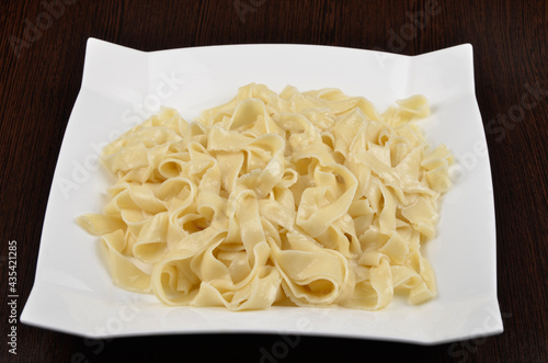 boiled vermicelli pasta in a white plate on a wooden background