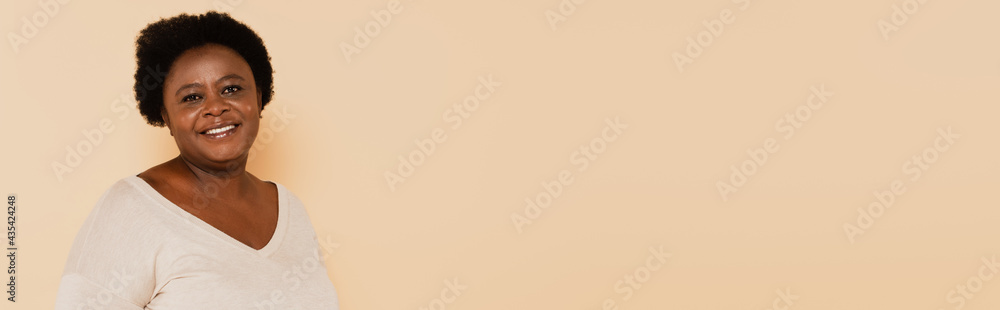 cheerful african american middle aged woman in pastel clothes isolated on beige, banner cheerful african american middle aged woman in pastel clothes isolated on beige, banner
