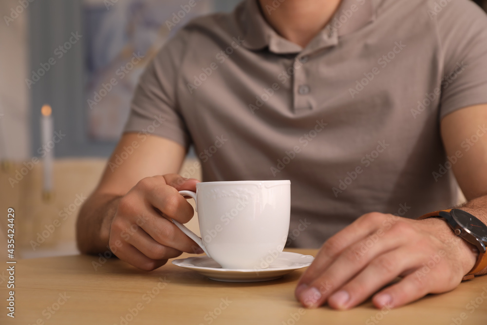 Man with cup of coffee at cafe in morning, closeup Man with cup of coffee at cafe in morning, closeup