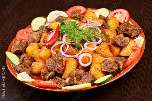a large dish with fried meat and stewed vegetables