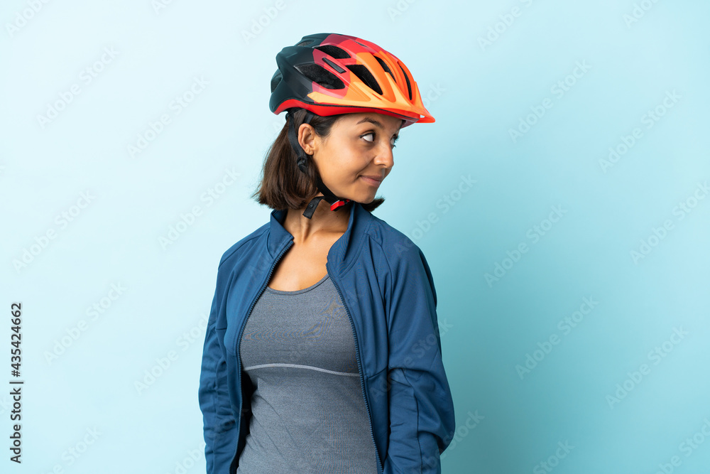 Young cyclist woman isolated on blue background . Portrait Young cyclist woman isolated on blue background . Portrait