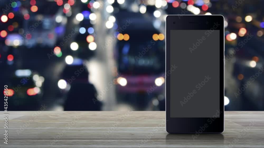 Play button on modern smart mobile phone screen on wooden table over blur colorful night light traffic jam street in city with cars, Business music online concept Play button on modern smart mobile phone screen on wooden table over blur colorful night light traffic jam street in city with cars, Business music online concept