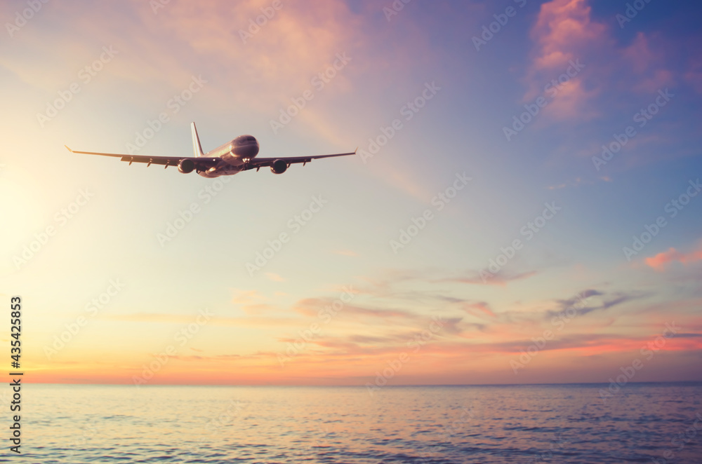 Airplane flying over tropical beach with smooth wave and sunset sky abstract background. Airplane flying over tropical beach with smooth wave and sunset sky abstract background.