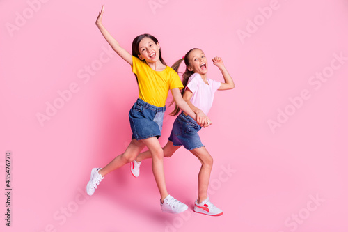 Full size profile photo of nice optimistic blond brown hair girls run wear t-shirt isolated on pink background