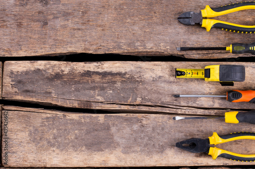 Set of construction tools on cracked wooden boards.