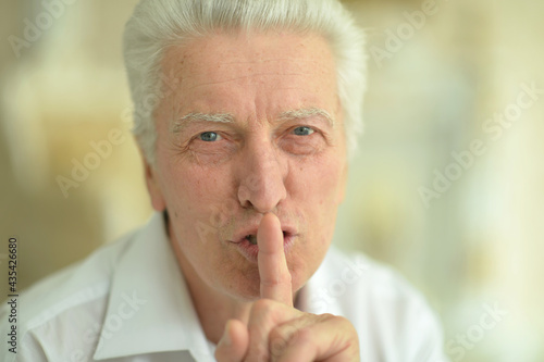 Wallpaper Mural Portrait of a senior man with finger on lips Torontodigital.ca