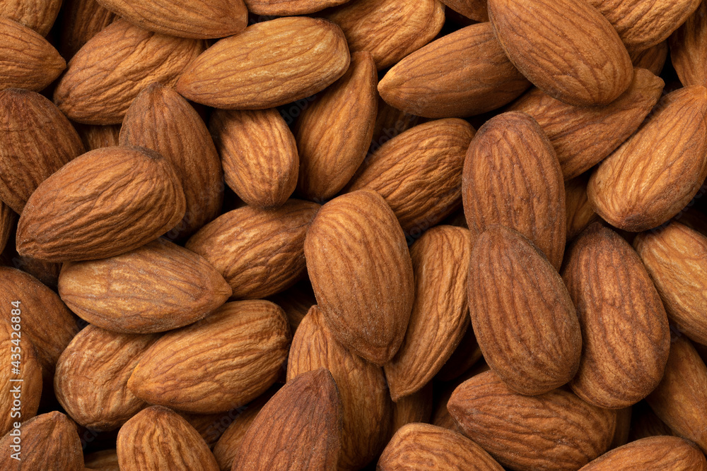 Peeled whole brown almonds close up full frame as a background Peeled whole brown almonds close up full frame as a background