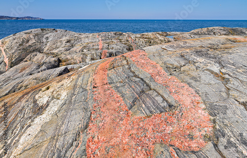 Smooth-cut bare rocks with a pink pegmatite dyke at the coast of the Barents sea in the vicinity of Grense Jakobselv, Finnmark, Norway